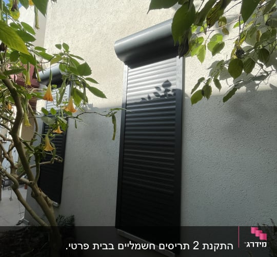 תריסי אלומיניום שחורים על קיר חיצוני